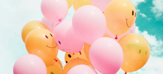 Symbolbild: Luftballons mit lachenden und traurigen Gesichern